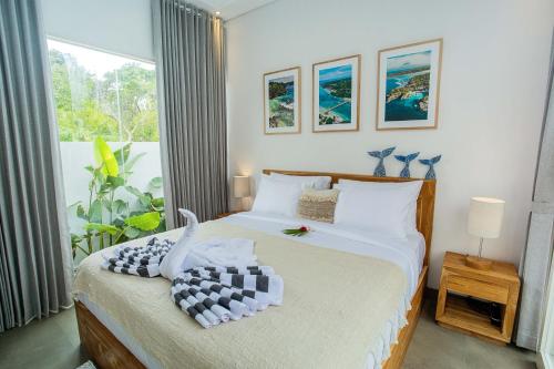 a bedroom with a bed and a large window at Alas Villa - 3 Bedrooms Private Pool Villa in Nusa Lembongan