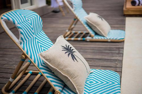 two blue rocking chairs with pillows on a deck at Alas Villa - 3 Bedrooms Private Pool Villa in Nusa Lembongan