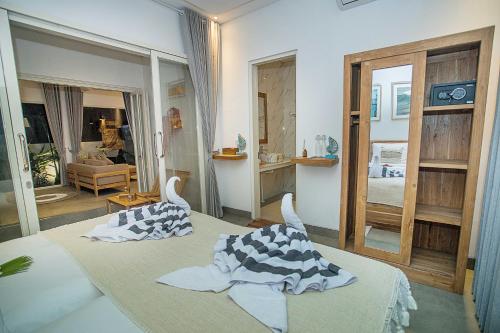a bedroom with two beds and a living room at Alas Villa - 3 Bedrooms Private Pool Villa in Nusa Lembongan