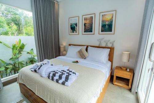 a bedroom with a bed and a large window at Alas Villa - 3 Bedrooms Private Pool Villa in Nusa Lembongan