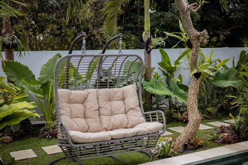 a wicker chair sitting in the middle of a garden at Alas Villa - 3 Bedrooms Private Pool Villa in Nusa Lembongan