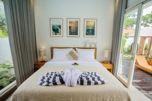 a bedroom with a bed with towels on it at Alas Villa - 3 Bedrooms Private Pool Villa in Nusa Lembongan