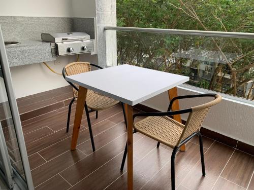 a white table and two chairs on a balcony at Espectacular apartamento en Ricaurte con BBQ in Ricaurte