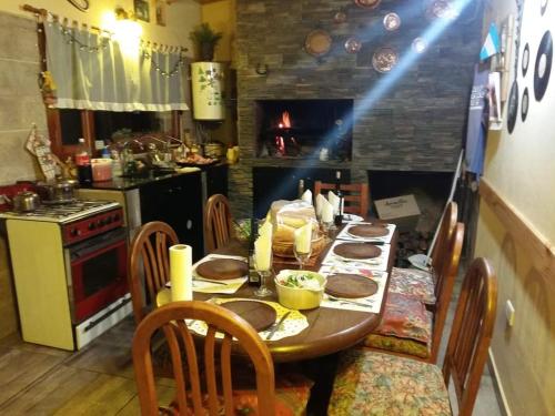 una cucina con tavolo in legno, sedie e un angolo cottura. di Alojamiento Corcovado a El Corcovado