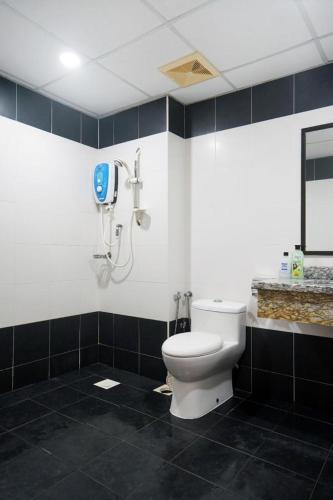a bathroom with a toilet and a phone on the wall at Cloud9 Studio Tiara Desaru in Desaru