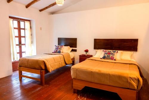 a bedroom with two beds in a room at La Rosa Wellness Lodge in Urubamba