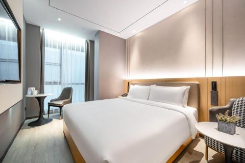 a hotel room with a white bed and a table at 雅庭酒店深圳海岸城南山地铁站店 in Shenzhen