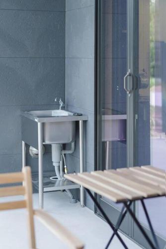 a bathroom with a sink and a bench next to a window at DAHARA n-1 in Minami Aso