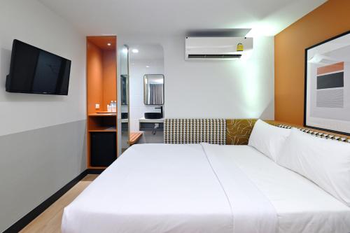 a bedroom with a white bed and a flat screen tv at Anya Nana at Sukhumvit Bangkok in Bangkok