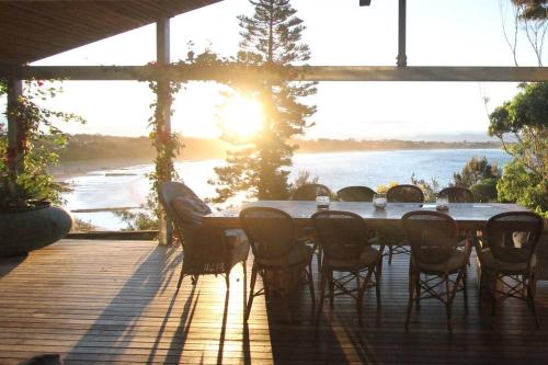 a table on a deck with a view of the water at Culburra Beach House in Culburra Beach