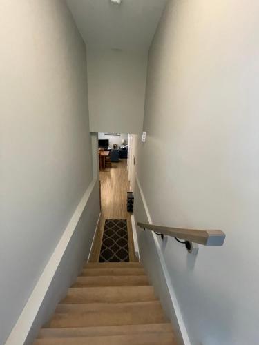 a stairway with a wooden railing and a stair case at Cozy Basement Apartment in Shediac