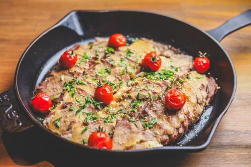 a pan with a steak with tomatoes on it at La'gent Stay Sapporo Odori Hokkaido in Sapporo