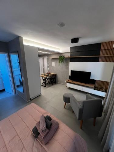 a living room with a couch and a television at Studio 307 in Marília