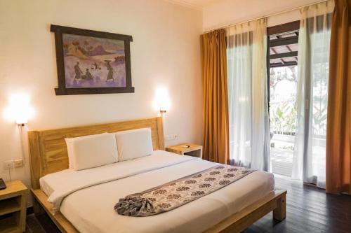 a bedroom with a large bed and a window at Royal Regantris Villa Karang in Gili Air