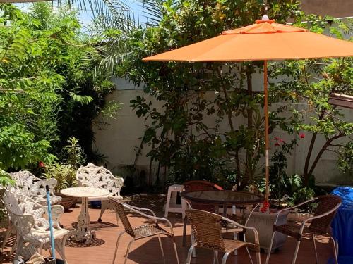 a patio with a table and chairs and an umbrella at Hotel Coqueiros in Valparaíso de Goiás