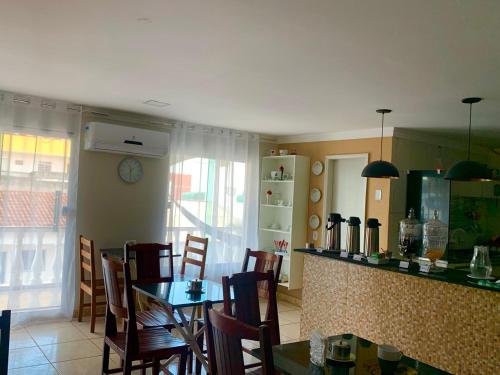 a kitchen and dining room with a table and chairs at Hotel Coqueiros in Valparaíso de Goiás
