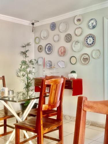 a dining room with a table and plates on the wall at Hotel Coqueiros in Valparaíso de Goiás