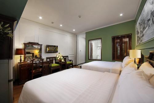 a bedroom with two beds and a desk with a desk at Sena Boutique Hotel & Travel in Hanoi