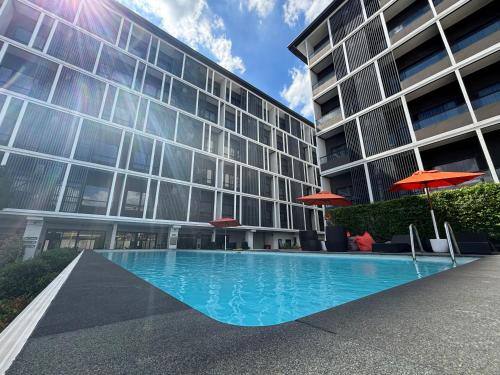 a swimming pool in front of a building at Moji Don Mueang Airport Hotel - Bangkok in Bangkok