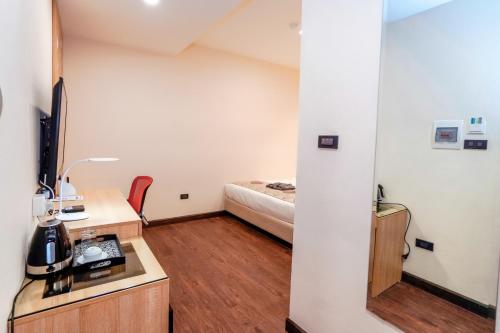 a small room with a bed and a desk at MOMIZI Hotel HAI PHONG in Hai Phong
