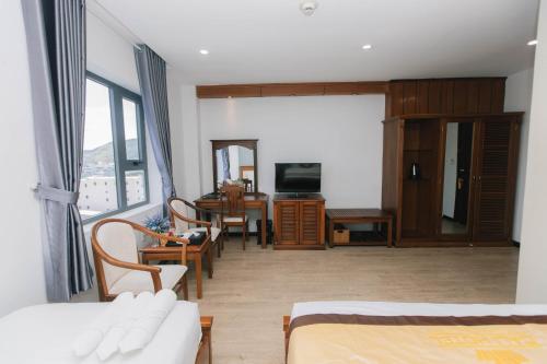 a living room with a couch and a table with a television at Cali Hotel Quy Nhơn in Quy Nhon