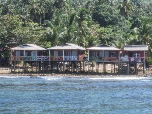 une rangée de maisons sur une plage au bord de l'eau dans l'établissement Mukut Seaview, à l'Île Tioman