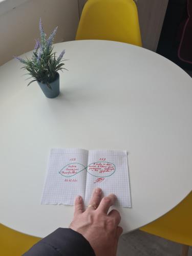 a person sitting at a table with their hands on a paper at Luxury Mall III apartments in Bacău
