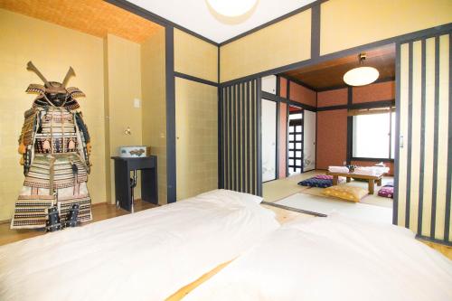 Una habitación con una cama y una estatua de un samurái. en SAMURAI HOUSE Yokohama, en Yokohama