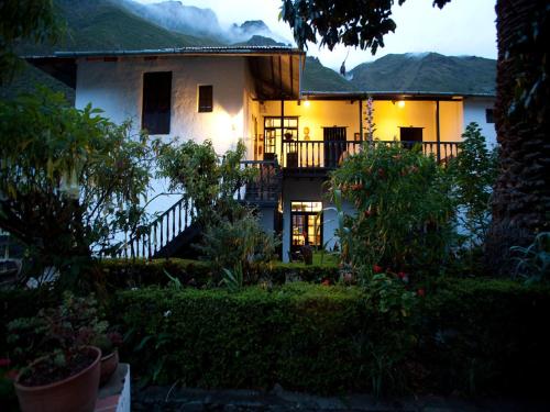 a house with a view of a garden in the night at El Albergue Ollantaytambo in Ollantaytambo