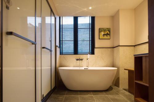 a bathroom with a large tub and a shower at 重庆复古阁楼酒店 in Chongqing