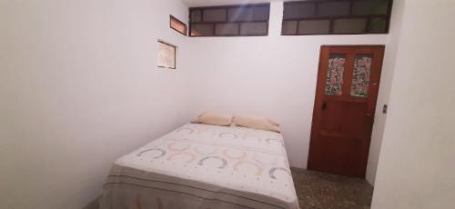 a small bed in a room with a door at Casa D'Andrea 201 in Flores