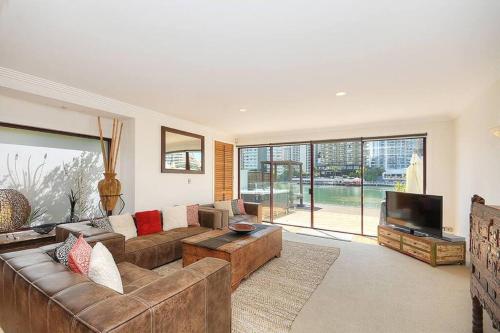 a large living room with a couch and a tv at Surfers Reflections Amazing views from your spa! in Gold Coast