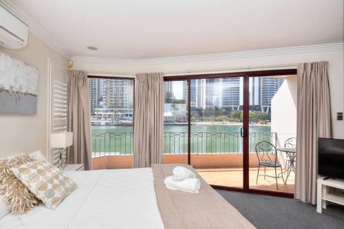 a bedroom with a large bed and a balcony at Surfers Reflections Amazing views from your spa! in Gold Coast