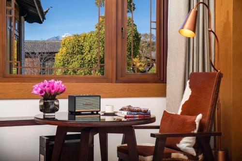 a table with a laptop computer on it next to a window at Hotel Indigo Lijiang Ancient Town by IHG in Lijiang