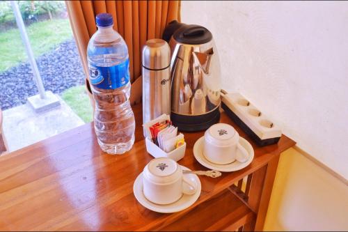 een tafel met twee kopjes en een fles water bij Mountview Bali in Kubupenlokan