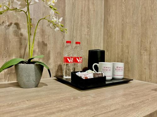 a tray with two bottles of water and cups on a table at Nemuru Grand Suites in Jakarta