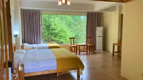 a bedroom with a bed and a large window at Longji Panorama Hotel 龙脊全景楼大酒店 in Longsheng