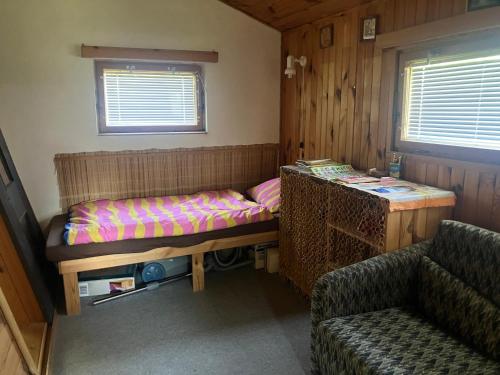a small room with a bed and a couch at Chata Mrhal, U Zemanů in Jivno