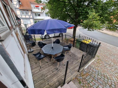 a table with chairs and an umbrella on a deck at Schöne Wohnung im Zentrum von Ahnatal in Weimar