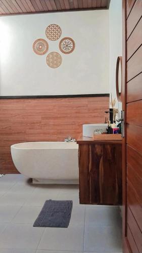 a bathroom with a bath tub and a sink at Pondok loji in Ubud
