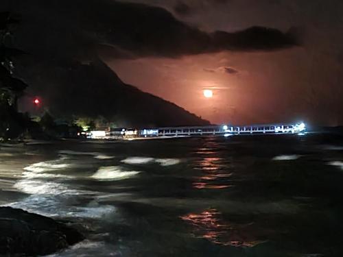 un train circulant le long de la plage la nuit dans l'établissement Mukut Seaview, à l'Île Tioman