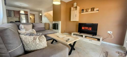 a living room with a couch and a television at Villa-Alpha in Kassandria
