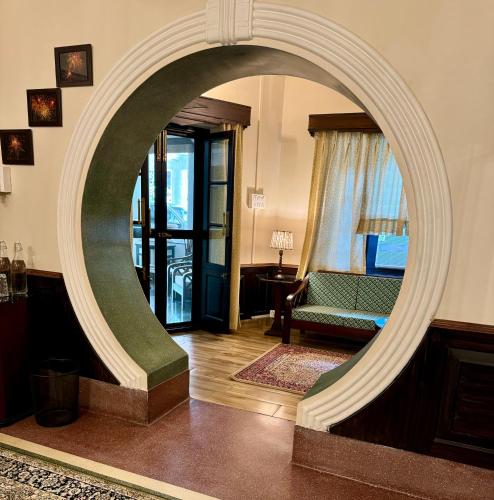 an archway in a living room with a green couch at Vijai Mahal - A Colonial Homestay in Ajmer
