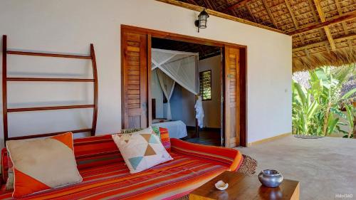 a living room with a couch and a bedroom at Manga Soa Lodge in Fascène - Befefika