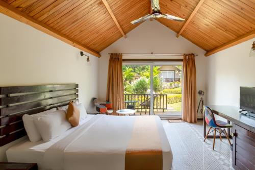 une chambre avec un grand lit et un balcon dans l'établissement Stone Wood Resort, Mandrem, à Mandrem
