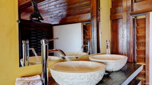 two sinks in a bathroom with two mirrors at Manga Soa Lodge in Fascène - Befefika