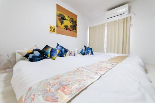 a bedroom with a white bed with blue pillows at 結 Osaka in Osaka