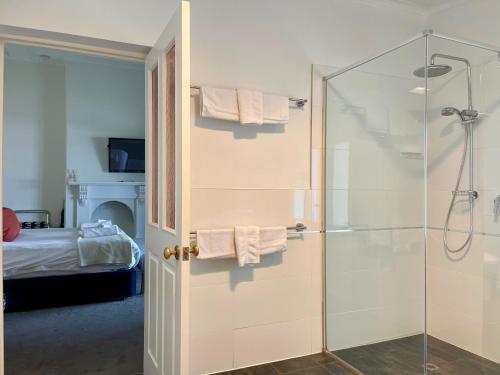a bathroom with a shower and a glass door at Pirathon Country Estate in Tanunda
