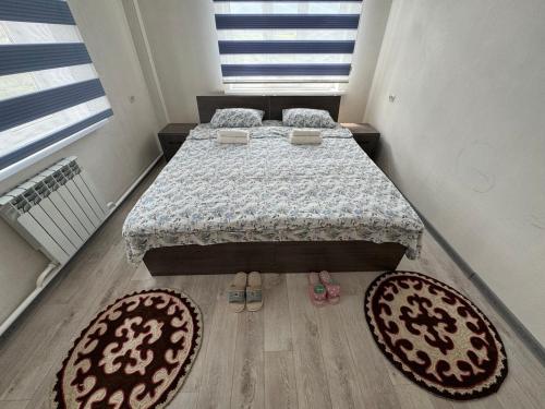 科奇科尔Guest House Umar的卧室配有一张床,地板上铺有2个地毯。