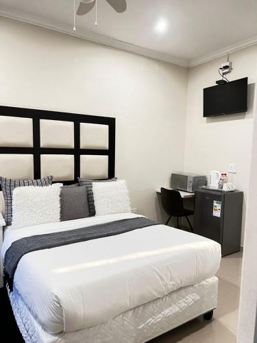 a bedroom with a large bed and a desk at Montrose BnB in Margate